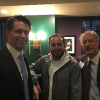 three well dressed men smiling together
